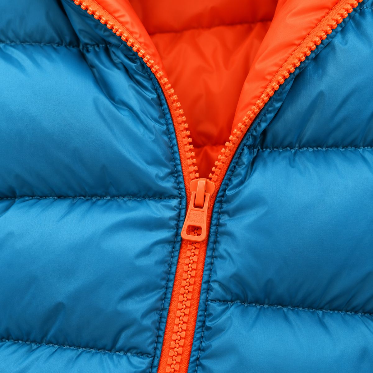 Blue - Close-up of a bright blue puffer jacket with an orange zipper and orange inner lining.