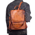 Brown leather backpack worn on a person's back against a white background