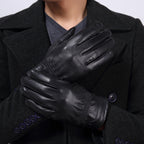 Person wearing black leather gloves with a dark coat and shirt.
