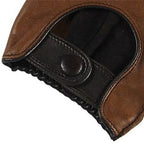 Close-up of a brown leather glove with a black strap and button on a white background