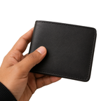 Hand holding a black leather wallet against a white background
