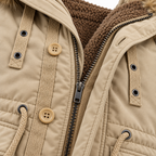 Khaki - Close-up of a beige quilted winter jacket with a brown sherpa-lined hood, tan buttons, and a black zipper.