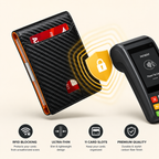A slim black carbon-fiber-pattern wallet shown next to a payment terminal, with yellow graphic waves and a lock icon indicating secure contactless payment. Four feature icons below read RFID Blocking, Ultra-Thin, 11 Card Slots, and Premium Quality.