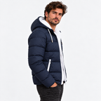 Navy Blue - A man wearing a navy blue puffer jacket with a white hood lining and white zipper details, paired with black jeans, against a plain white studio background.