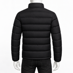 Black - A black puffer jacket shown from the back on a mannequin, featuring horizontal quilting and a stand-up collar, paired with dark jeans against a plain white background.