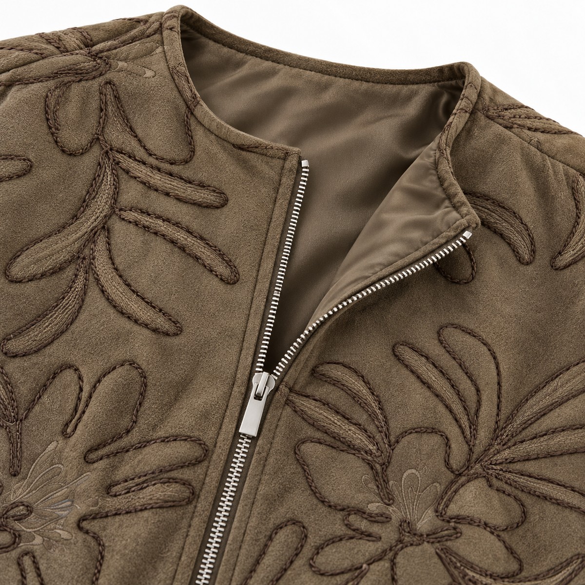 Green - Close-up of a taupe-brown suede jacket with floral embroidery and a silver zipper, shown against a white background.