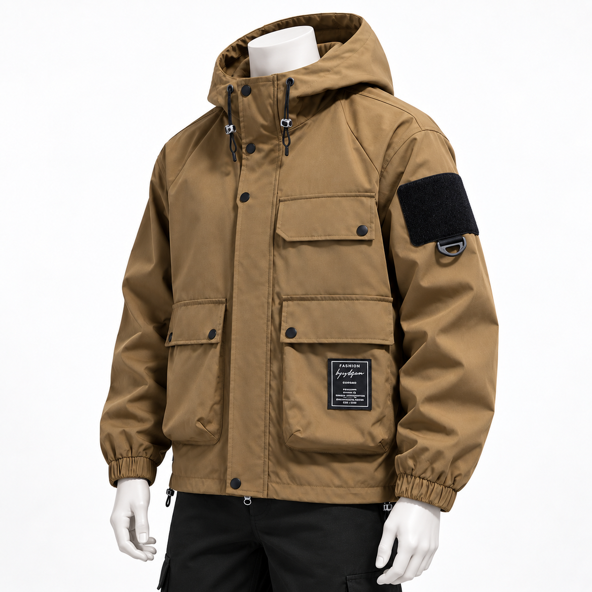 Khaki - A hooded utility jacket in tan brown, displayed on a white mannequin against a clean white background. The jacket features multiple front pockets, a black velcro patch on the upper left sleeve, and a black brand patch on the lower front pocket.