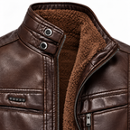 Brown -  Close-up of a brown faux leather jacket with a plush brown sherpa lining, featuring a high collar with snap buttons and a front zipper.