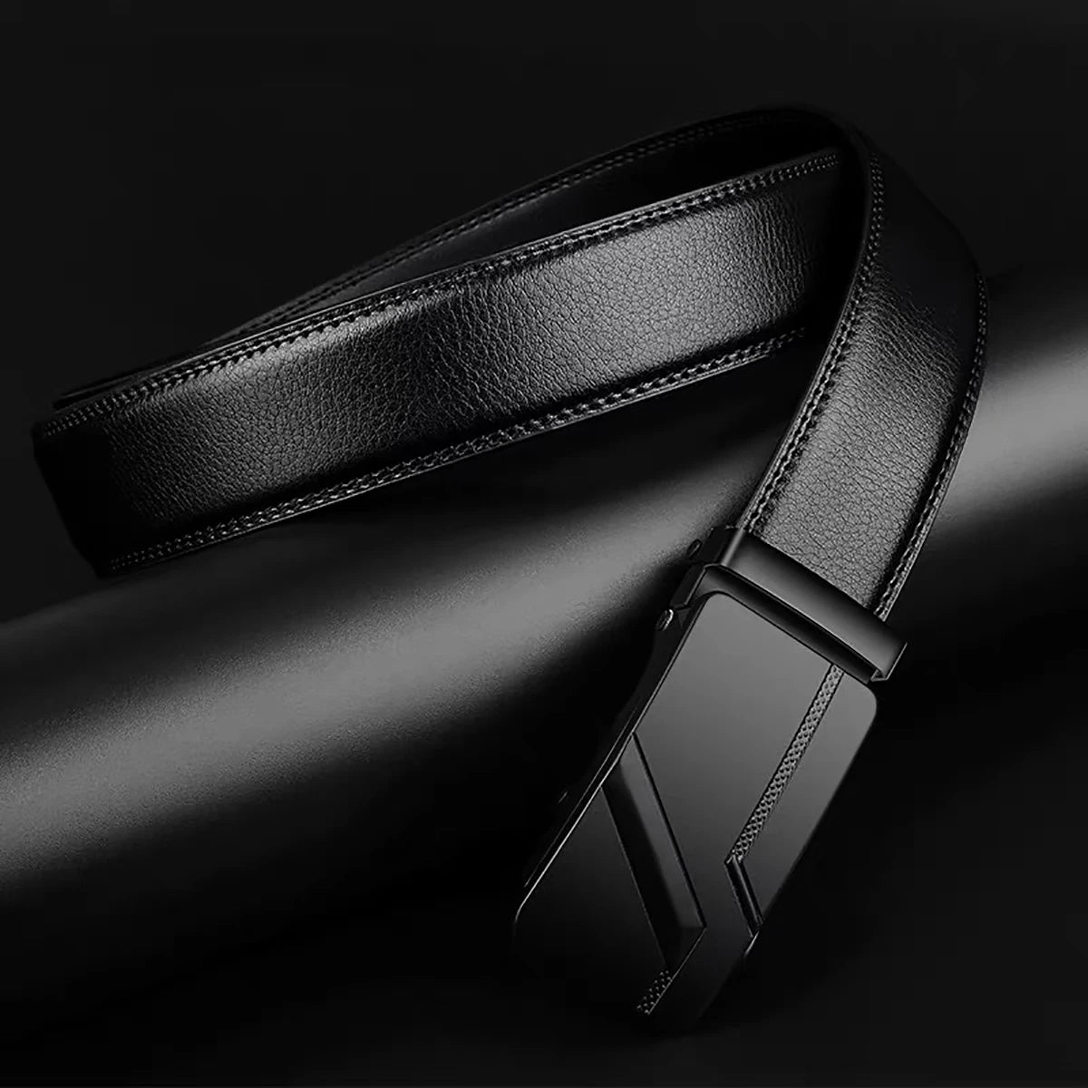 Black leather belt with a metallic buckle on a dark background