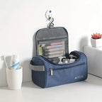 Blue travel toiletry bag with items on a white surface