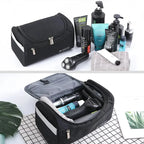 Black toiletry bag with grooming products on a white background