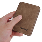 Brown leather wallet held by a hand with 'baellerry' branding on a white background