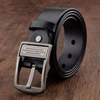 Black leather belt with silver buckle on a wooden surface