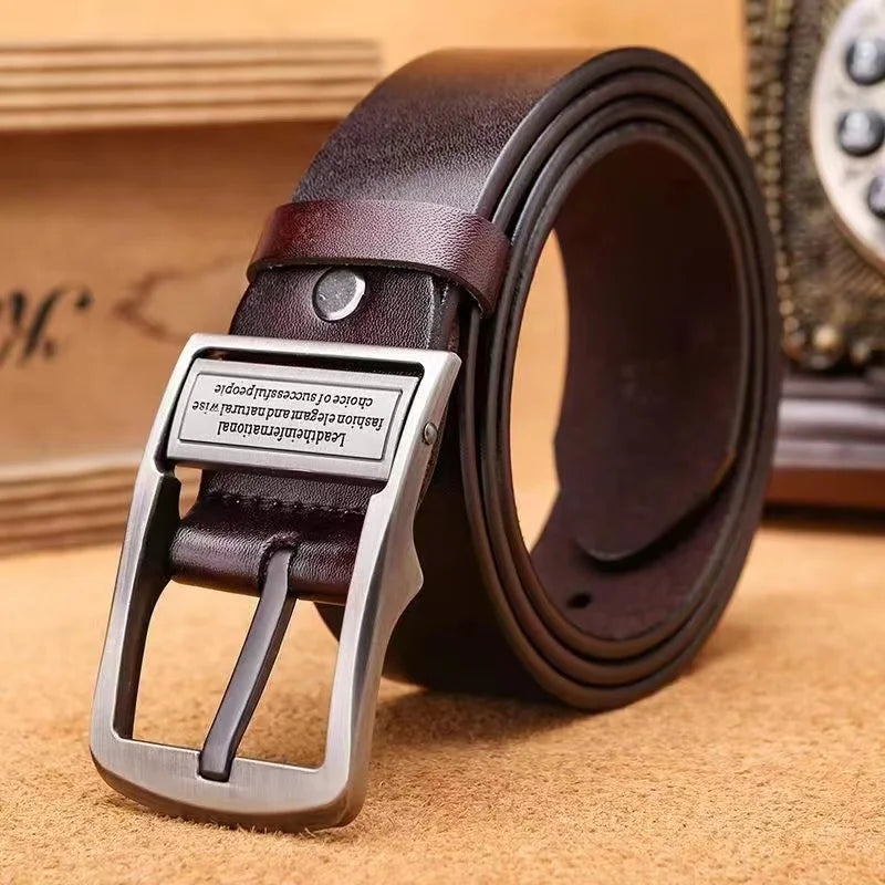 Brown leather belt with silver buckle on a textured surface