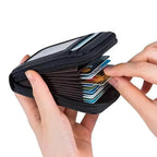 Black cardholder with cards being inserted by hands on a white background