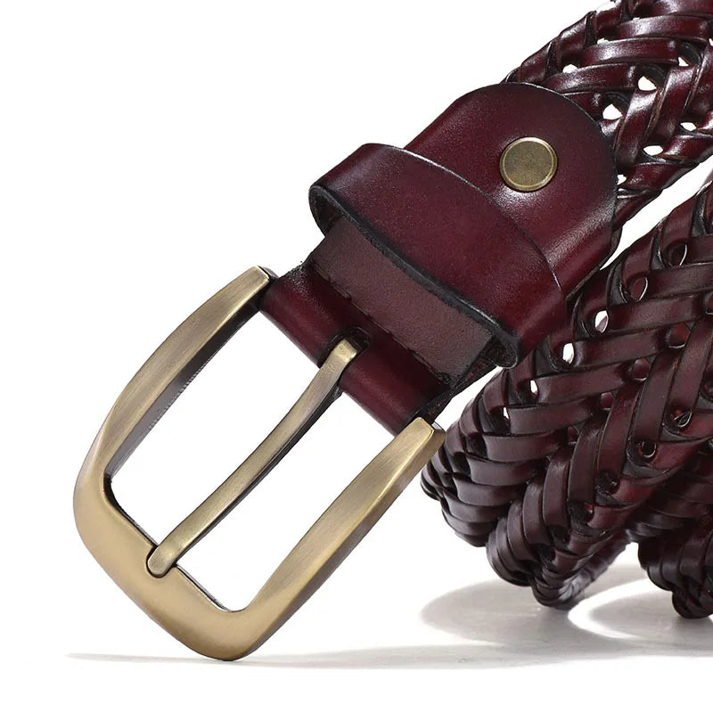 Close-up of a braided belt with a gold buckle on a white background