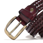 Close-up of a braided belt with a gold buckle on a white background