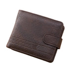Brown leather wallet on a wooden surface with a pen and phone in the background