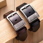 Two leather belts with silver buckles on a wooden surface
