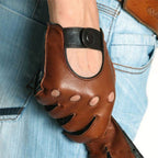 Brown leather glove with black accents held by a person wearing blue jeans.