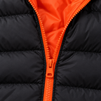 Orange - Close-up of a black puffer jacket with a bright orange zipper and matching orange inner lining.