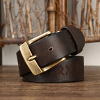 Brown leather belt with gold buckle on a wooden surface